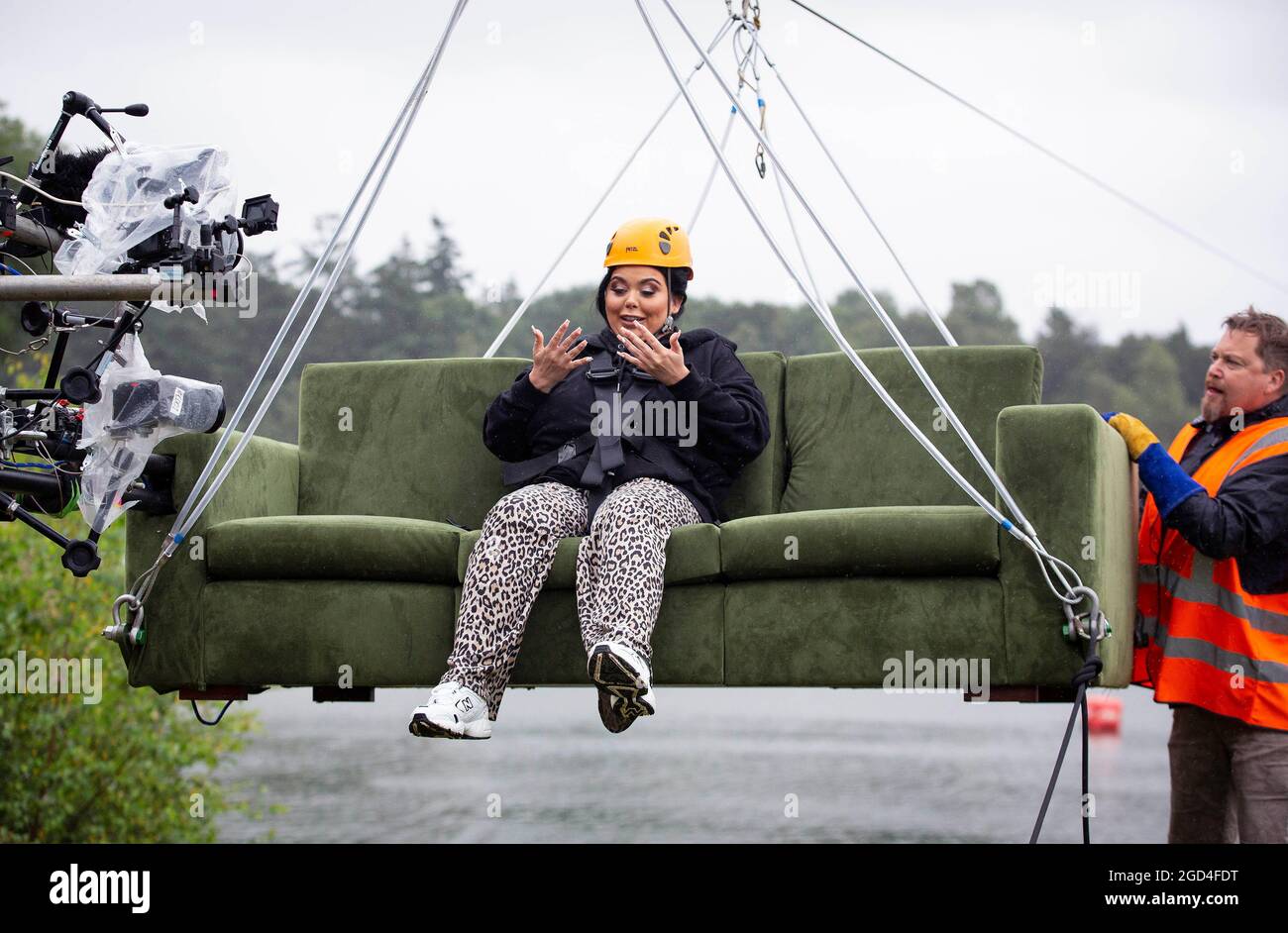 EDITORIAL USE ONLY Scarlett Moffatt, sitting on her sofa, zip lines for 200-metres, 25 metres above the ground at Buckland Park in Surrey, as research highlights the public's post-lockdown 'unbreakable bond' with their couches, revealing that almost 1 in 6 people surveyed admitted to cancelling on friends for a night in, despite Coronavirus restrictions being eased. Issue date: Wednesday August 11, 2021. Stock Photo