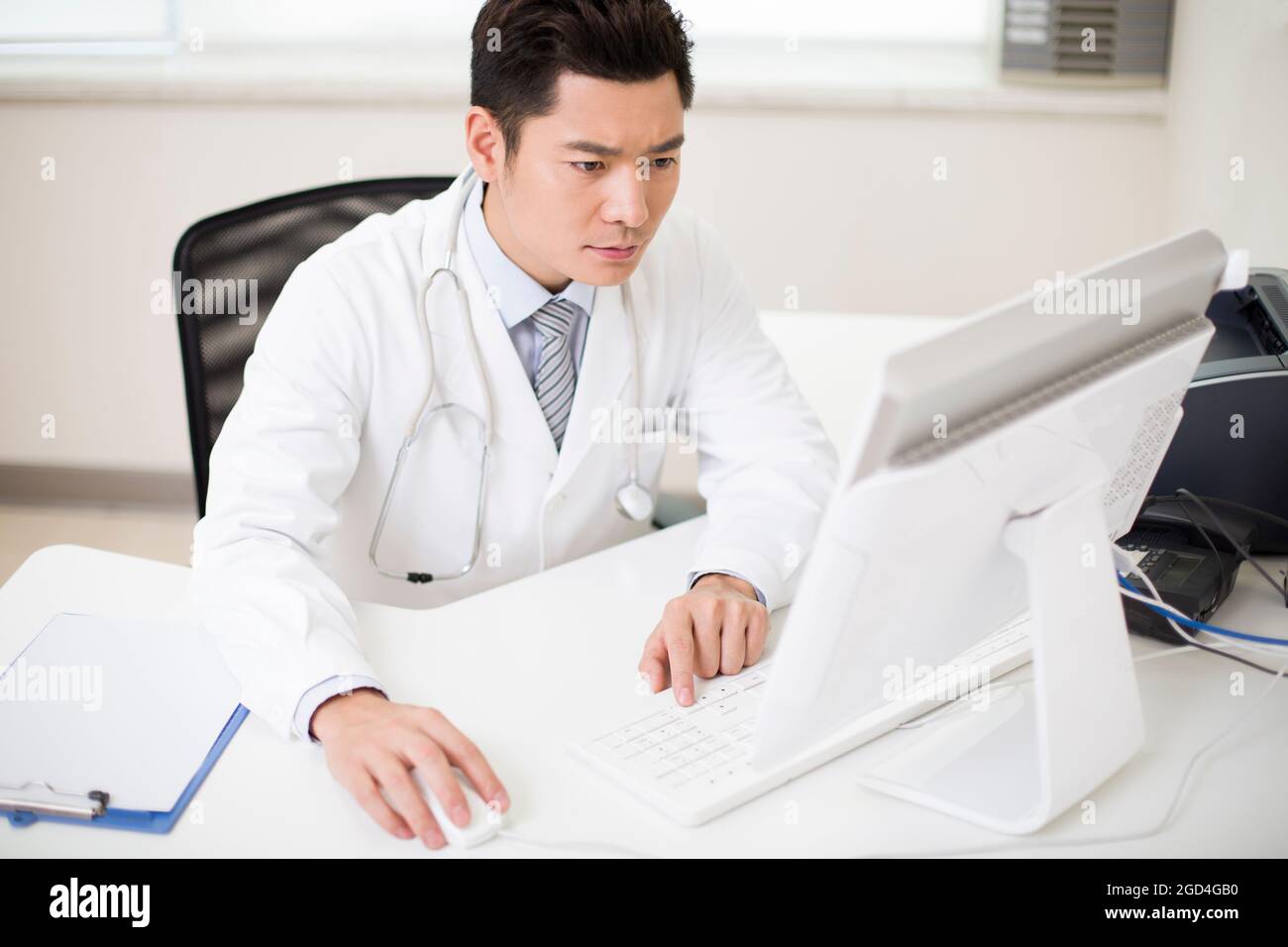 Young male doctor working in office Stock Photo