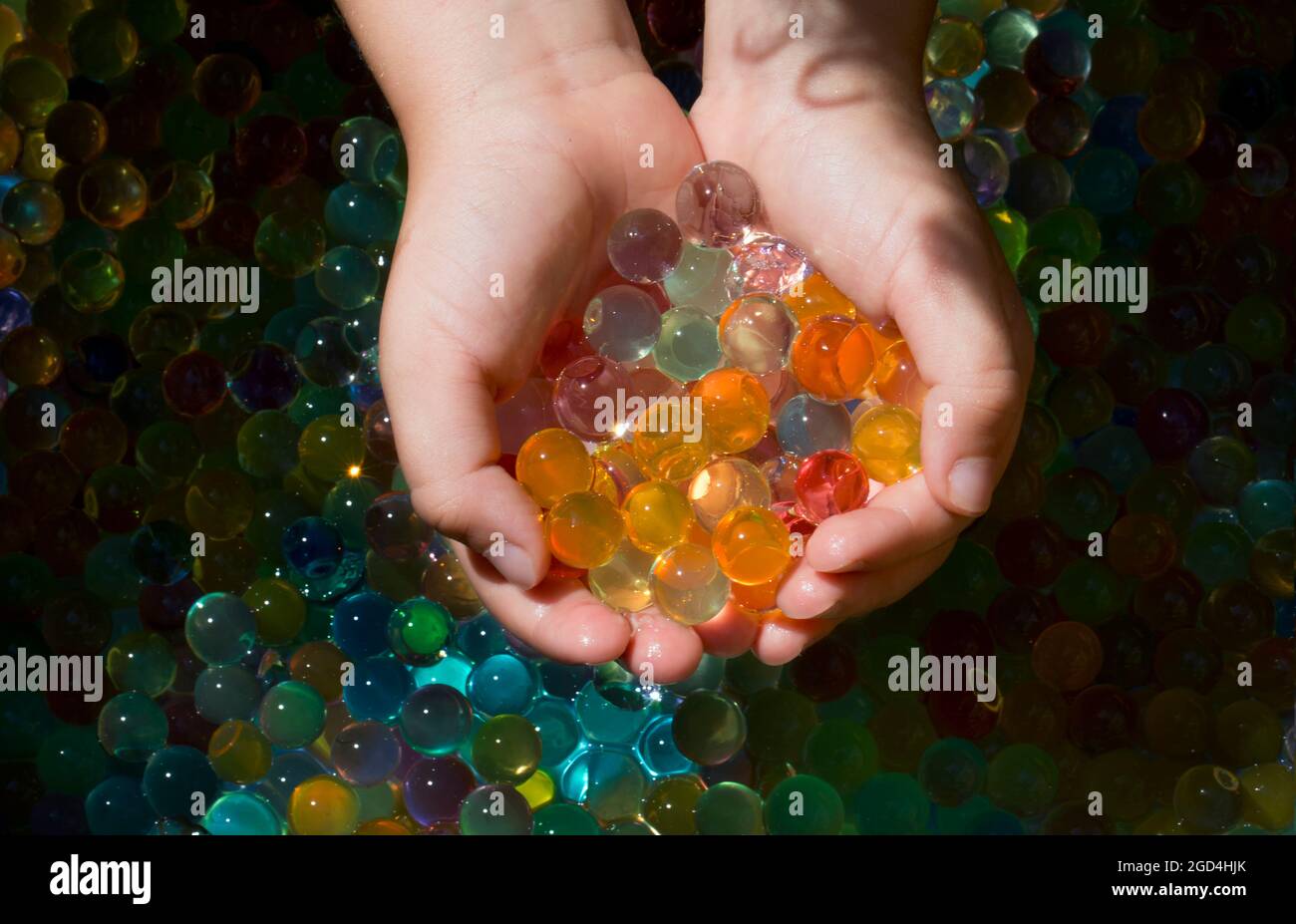 close-up shot of multiple colored balls (orbis) in the small hands of a child. Stock Photo