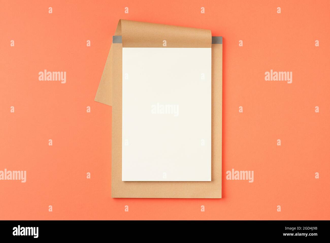 Open notebook on orange background. Stock Photo
