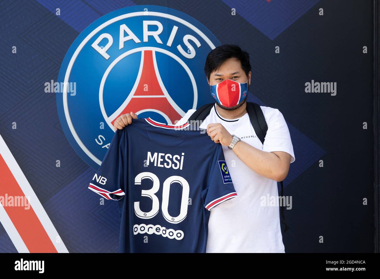 Paris, France. 11th Aug, 2021. A supporter shows a jersey of PSG's Argentinian football player Lionel Messi, that he has just bought at the Paris-Saint-Germain (PSG) football club store on the Champs Elysees avenue in Paris on August 11, 2021. Messi signed on August 10, 2021 a two-year deal with PSG with the option of an additional year. The 34-year-old will wear the number 30 in Paris, the number he had when he began his professional career at Barca. Photo by Raphael Lafargue/ABACAPRESS.COM Credit: Abaca Press/Alamy Live News Stock Photo
