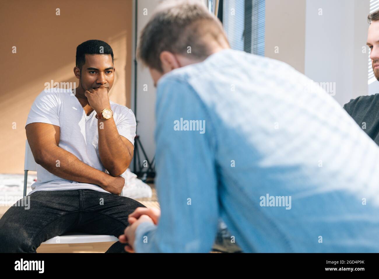 Closeup back view of depressed young man sharing mental problem
