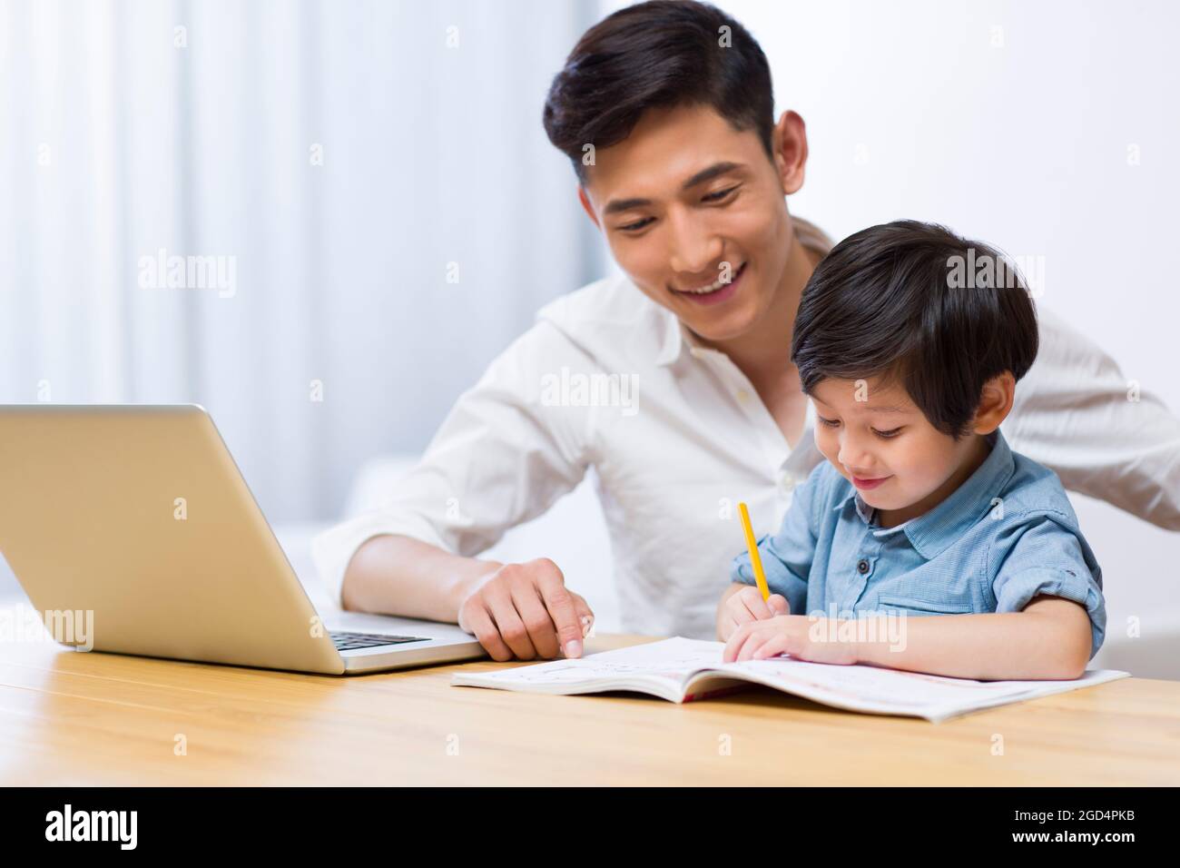 Father helping son with his homework in living room Stock Photo - Alamy