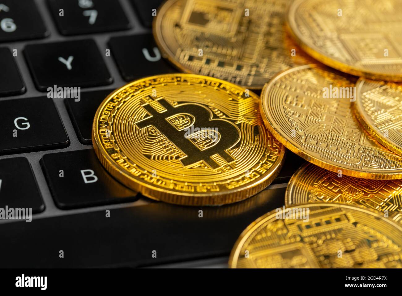 Gold bitcoin coins on laptop keyboard. Stock Photo