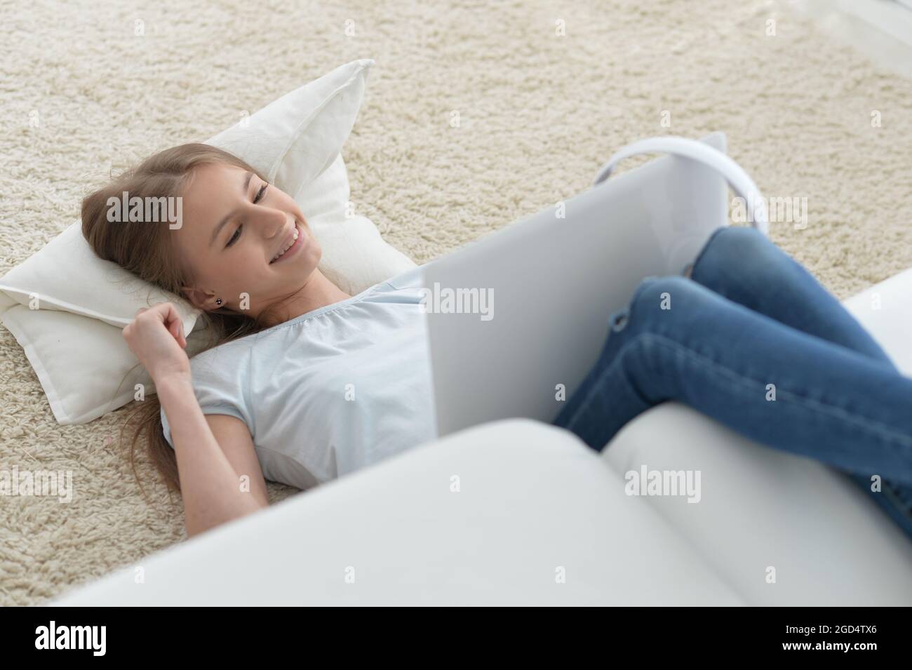 Cute girl using laptop while lying at home Stock Photo - Alamy