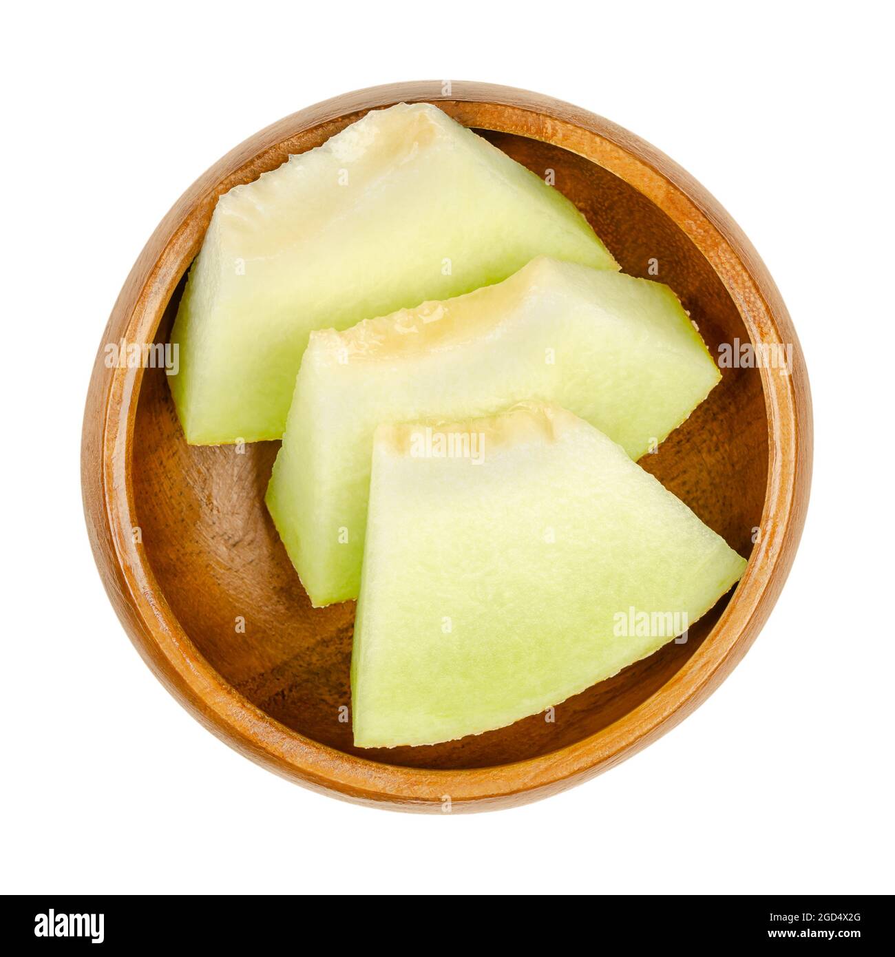 Galia melon slices, in a wooden bowl. Triangular and ready-to-eat pieces of a freshly cut and ripe fruit of Cucumis melo var. reticulatus. Stock Photo