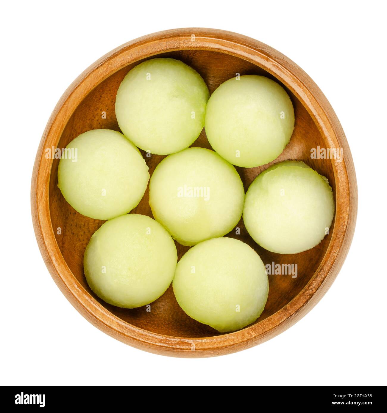 Galia melon balls, in a wooden bowl. Freshly cut out with a melon baller, ready-to-eat pieces of a ripe fruit of Cucumis melo var. reticulatus. Stock Photo
