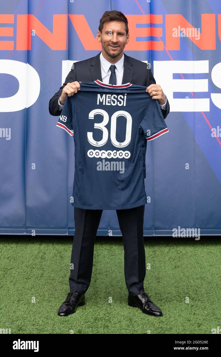 Argentinian football player Lionel Messi holds-up his number 30 shirt while  standing on the pitch during a press conference at the French football club  Paris Saint-Germain's (PSG) Parc des Princes stadium in