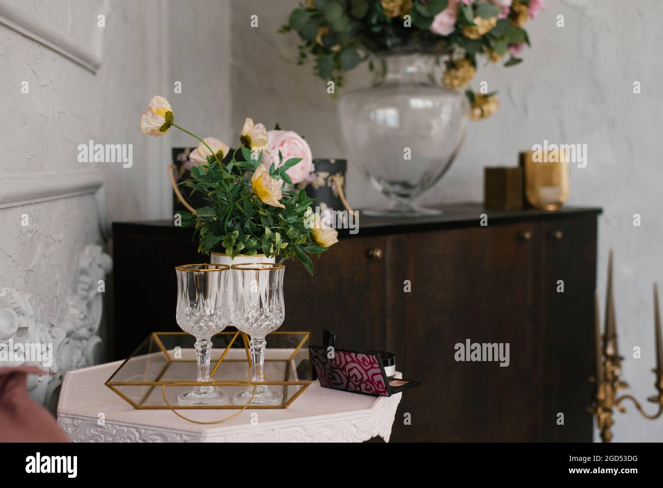 Wine glasses and a bouquet of flowers in a vase in the living room as a ...