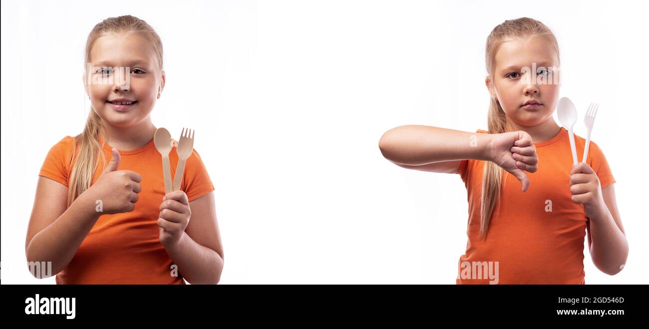 Cute caucasian little girl holding bamboo cutlery and plastic cutlery on a white background. Bamboo cutlery made of wood. Zero waste concept, recyclin Stock Photo