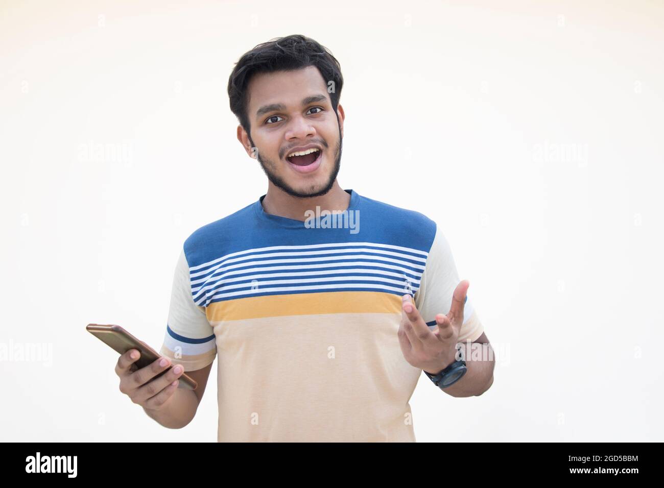 Portrait of surprised young man holding Mobile phone Stock Photo - Alamy