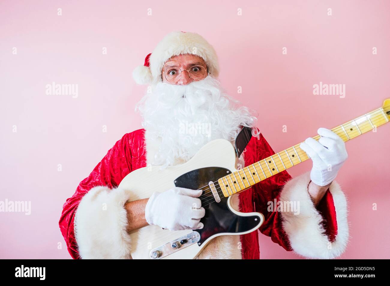 Man dressed as Santa Claus playing electric guitar Stock Photo