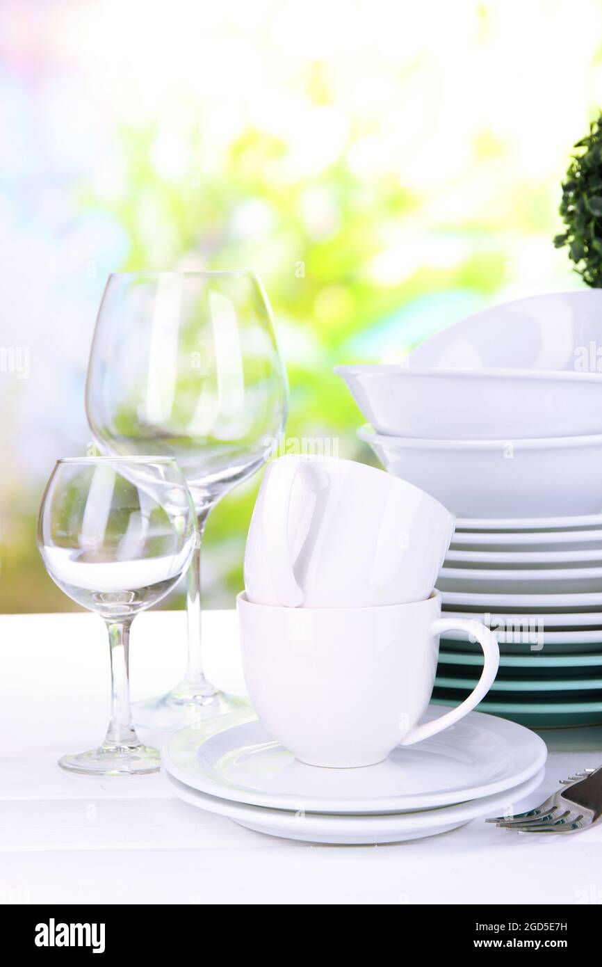 Clean dishes on table on natural background Stock Photo - Alamy