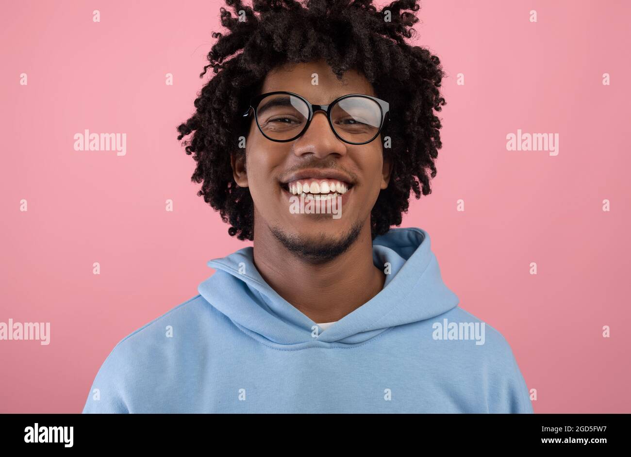 Portrait of joyful black teenager with pleasant smile wearing glasses ...