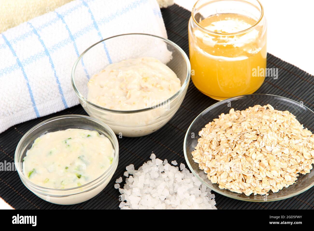 Homemade facial mask with oats and honey on bamboo mat, isolated on