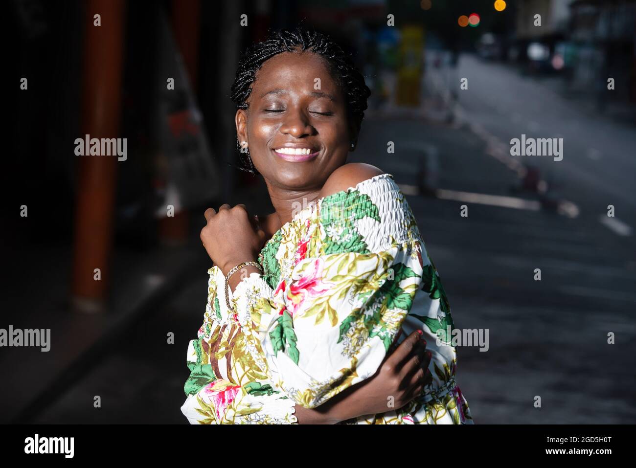 young woman standing outdoors smiling with her eyes closed Stock Photo ...