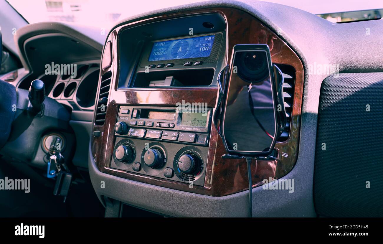 Wireless car phone charger fixed on the car panel. Colored, full frame