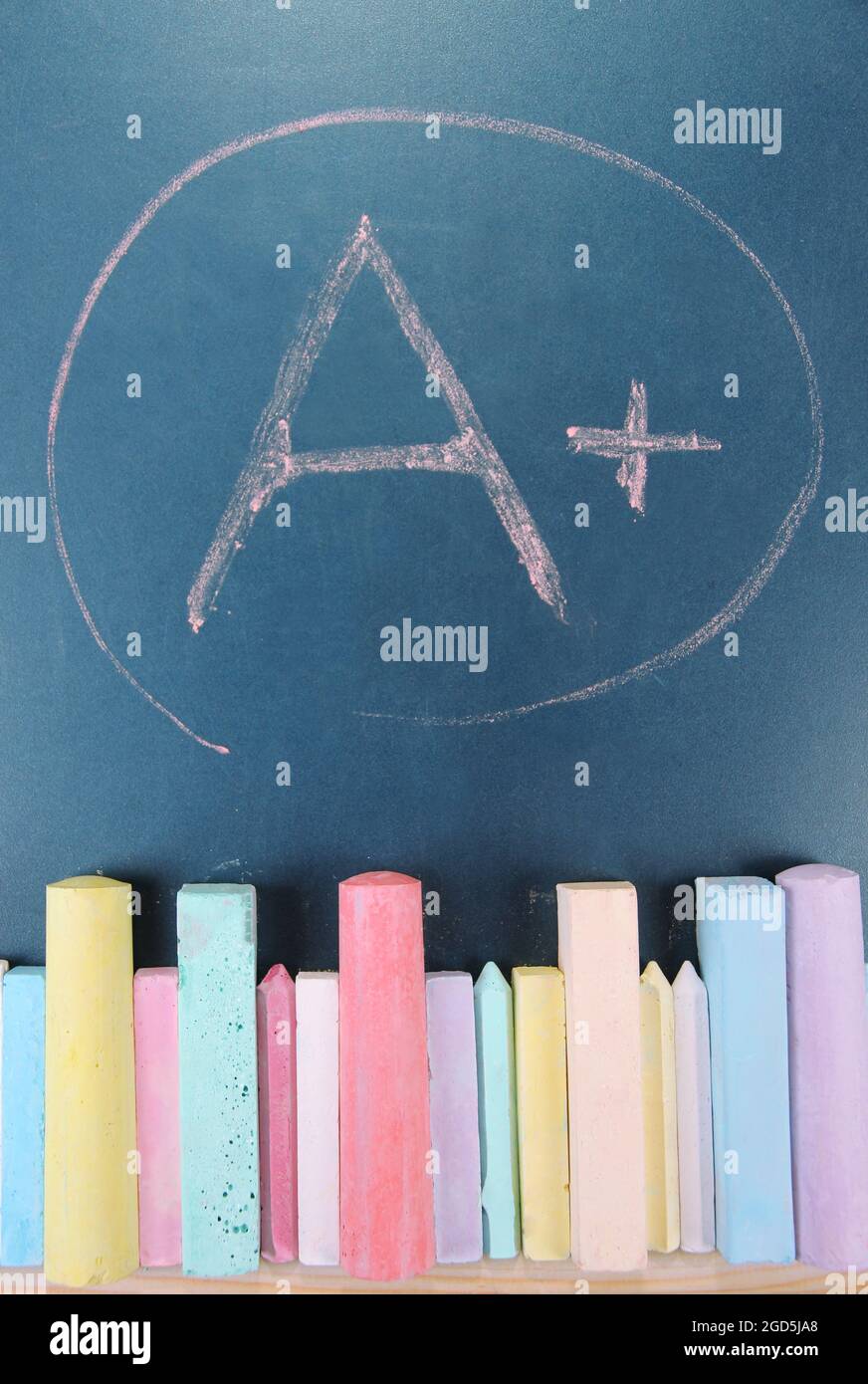 Education rating and colorful chalks on school desk Stock Photo