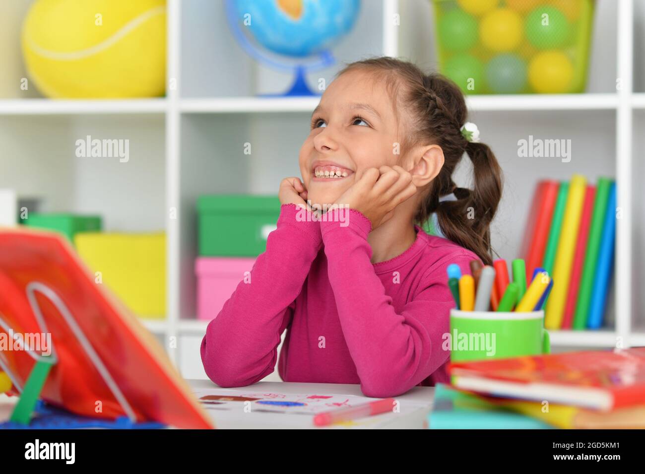 Porait of cute little girl studying at home Stock Photo - Alamy