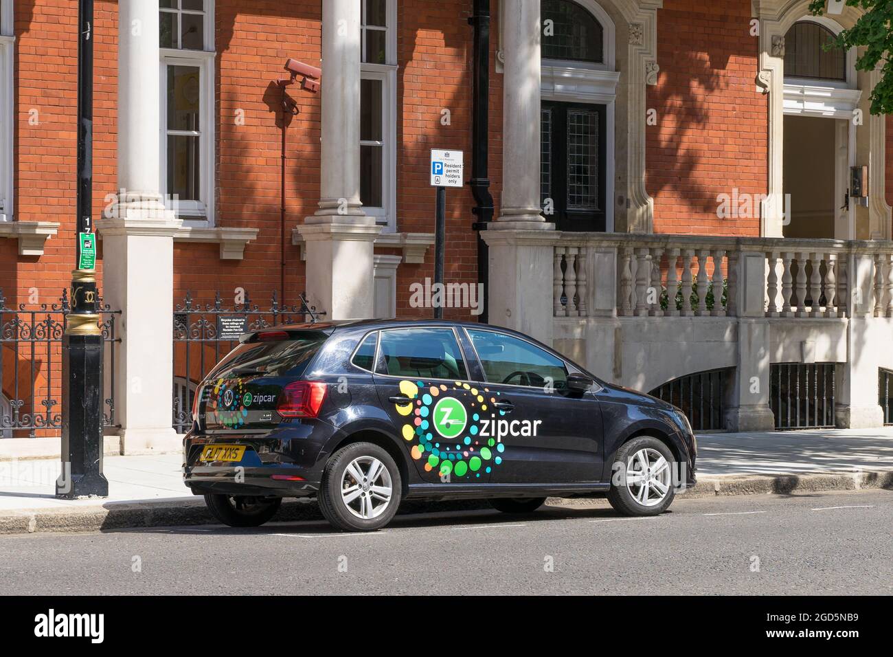 A Zipcar parked at the side of a road in Kensington. A car sharing vehicle with the companies logo on the side. London - 11th August 2021 Stock Photo