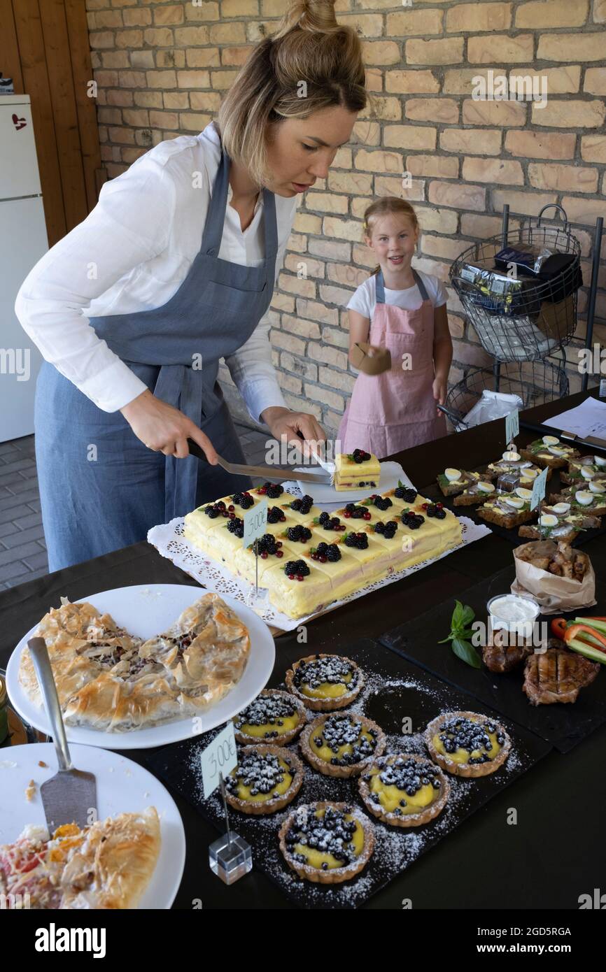 The Home Cafe “Tie jau tikai pumpuriņi” host serving sweet cakes for guests in Sigulda city, Latvia Stock Photo