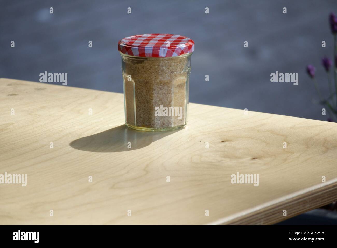 Jam jar and Demerara sugar on table Stock Photo