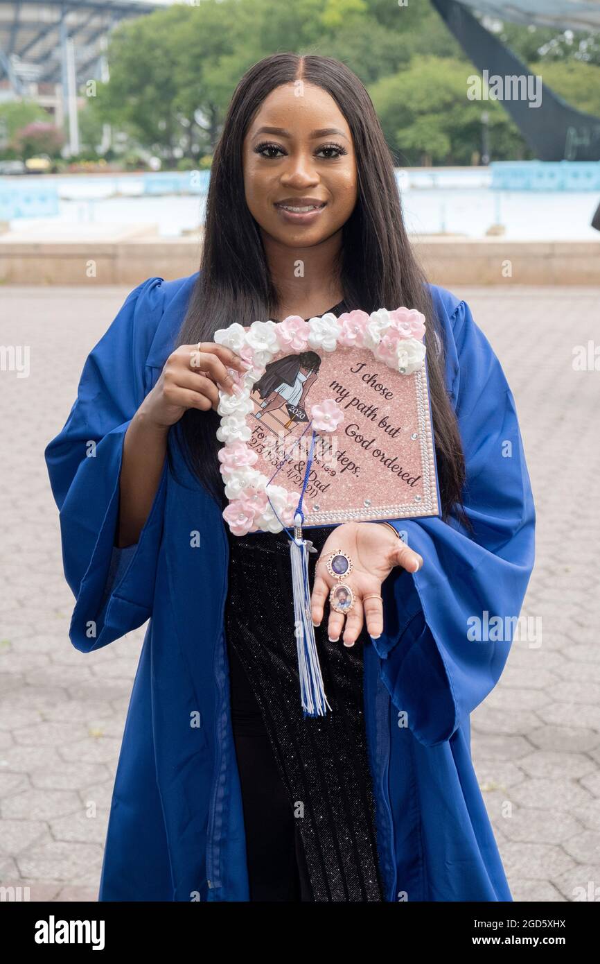 A beautiful Plaza College graduate poses with her decorated cap which thanks god & her parents. In Flushing Meadows Corona Park in Queens. Stock Photo