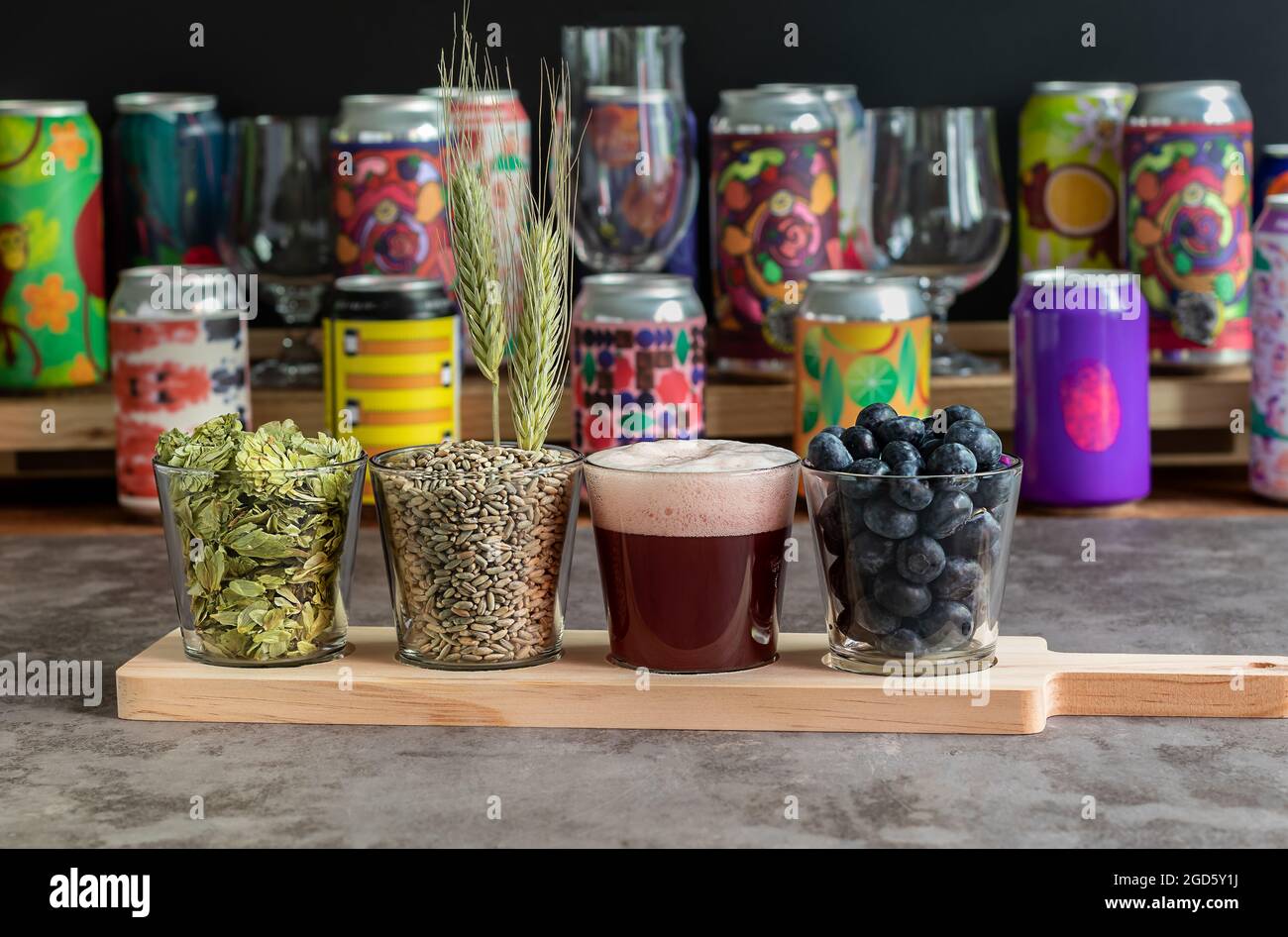 Sour fruited blueberry IPA with ingredients. Wooden board for flight set craft beer tasting Stock Photo