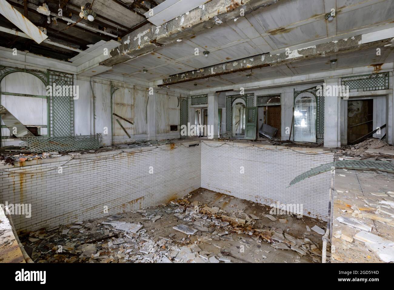 The indoor swimming pool was in ruin, with debris fallen from the