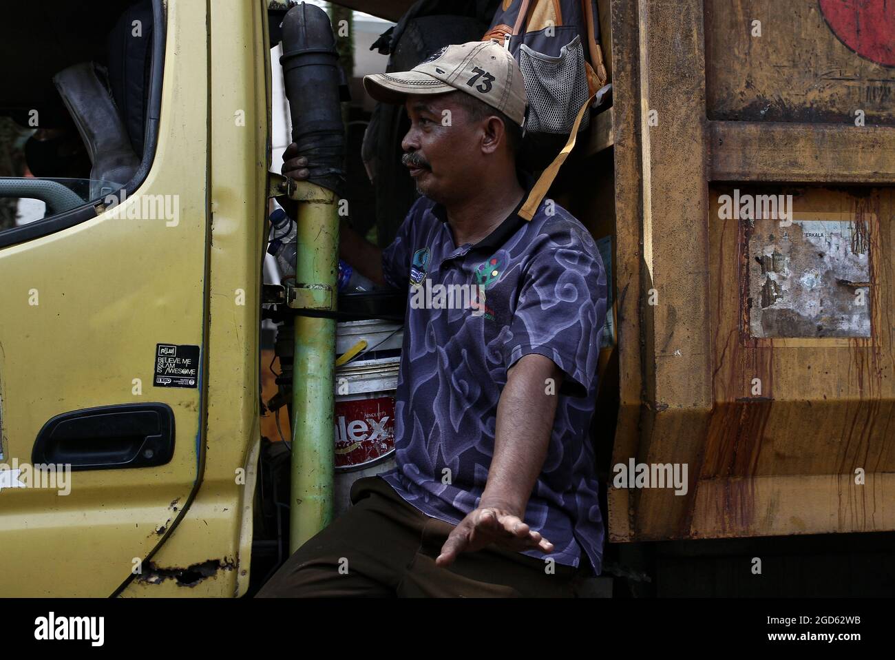 Bandung, West Java, Indonesia. A garbage man is in a garbage truck that goes around every house picking up trash. Stock Photo