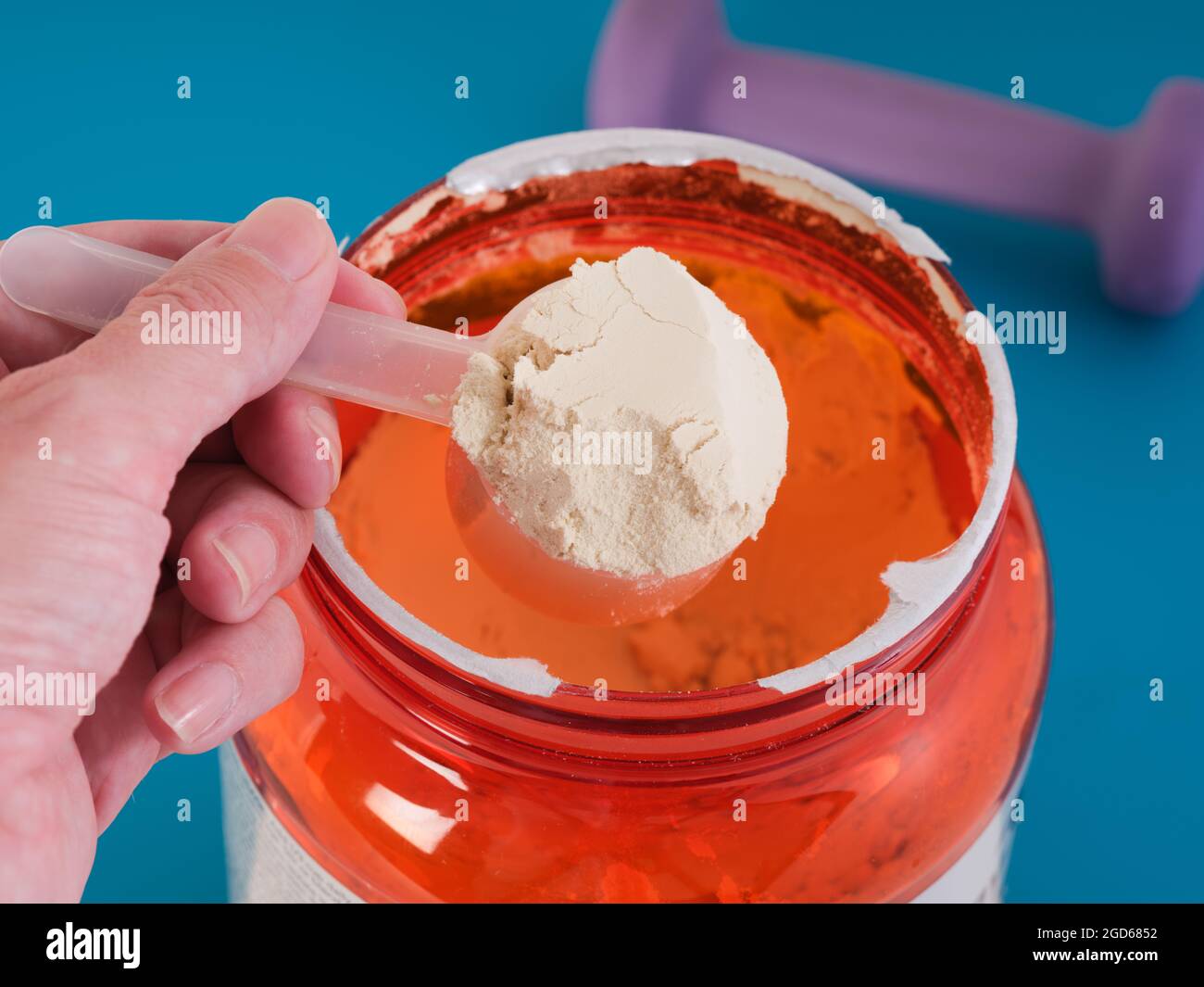 A man holding a scoop of soy protein isolate powder in his hand. Close up. Stock Photo