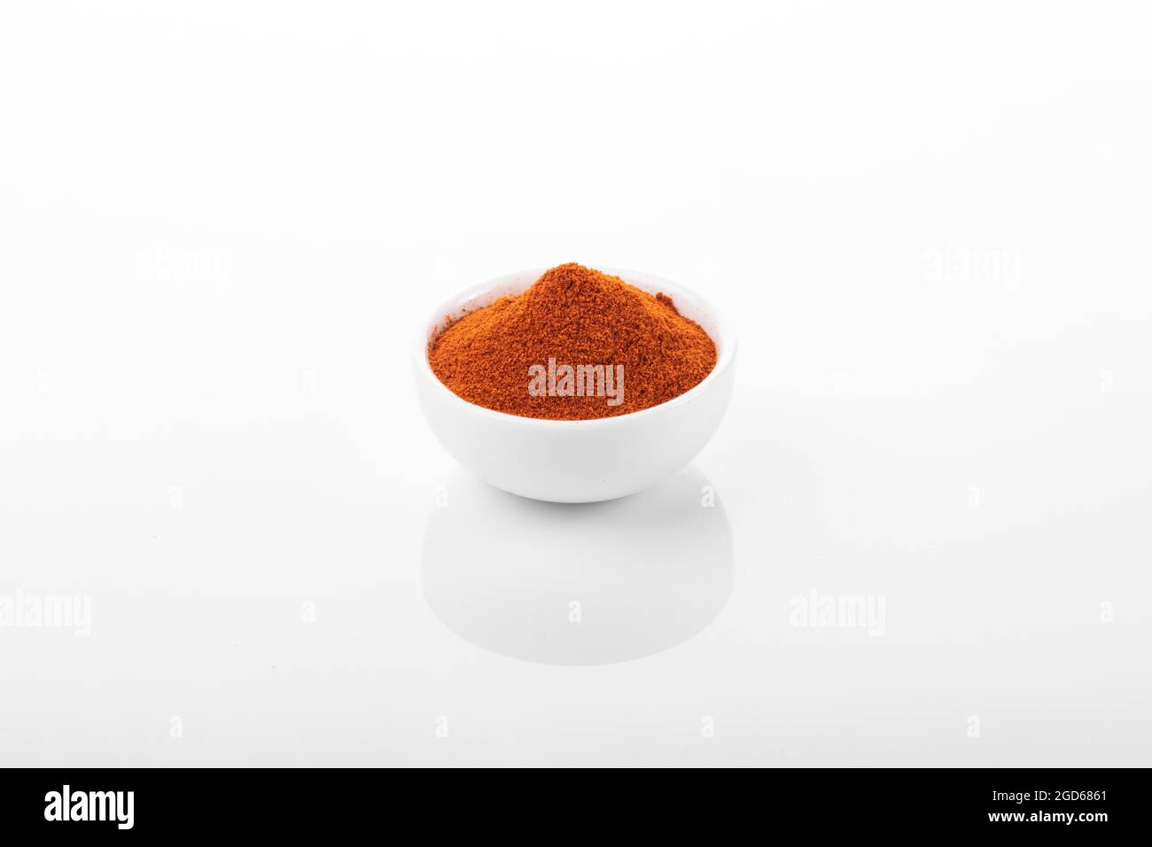 Red hot pepper powder. Pepper powder in white bowl, on white background. Stock Photo