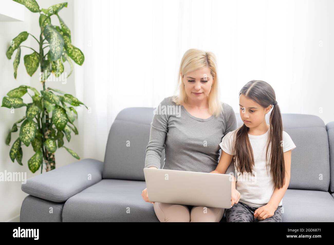 Helpful mother explaining to daughter about using a laptop Stock Photo