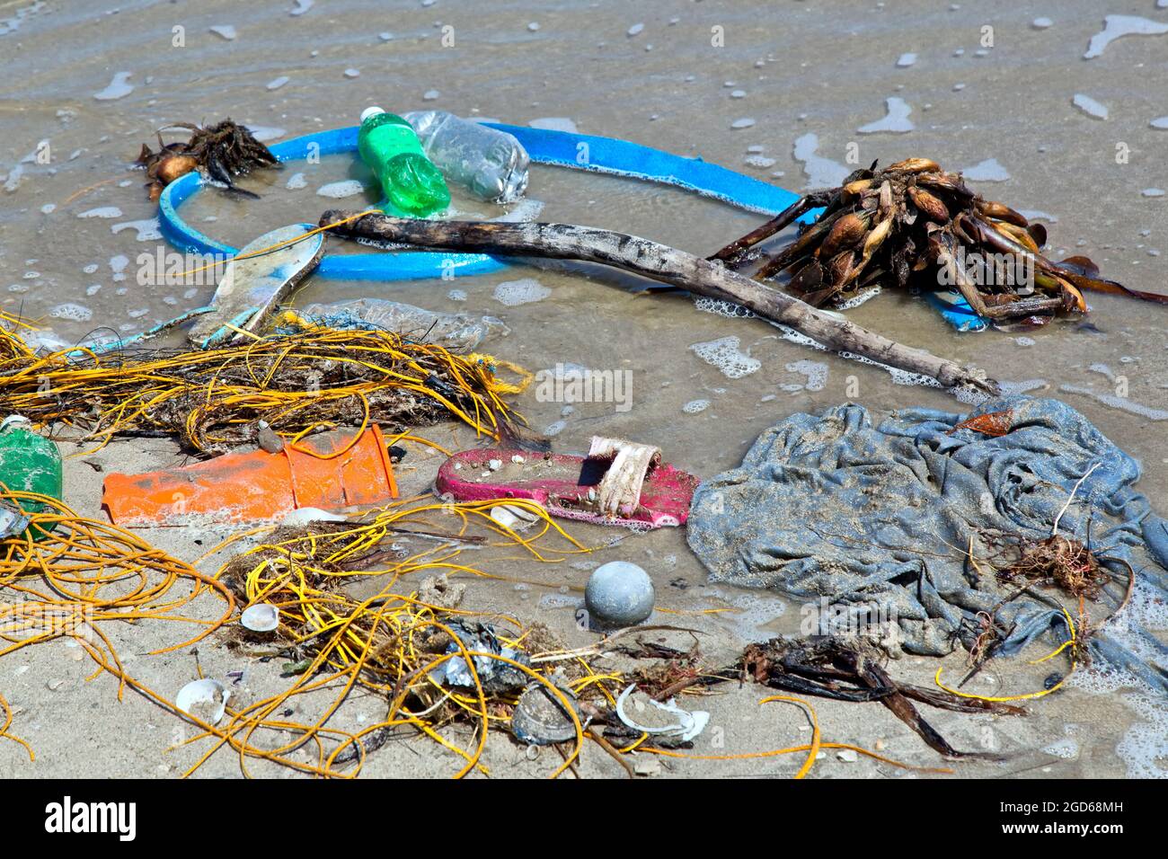 Shoreline, incoming tide depositing miscellaneous plastics, Gulf Of Mexico, Texas. Stock Photo