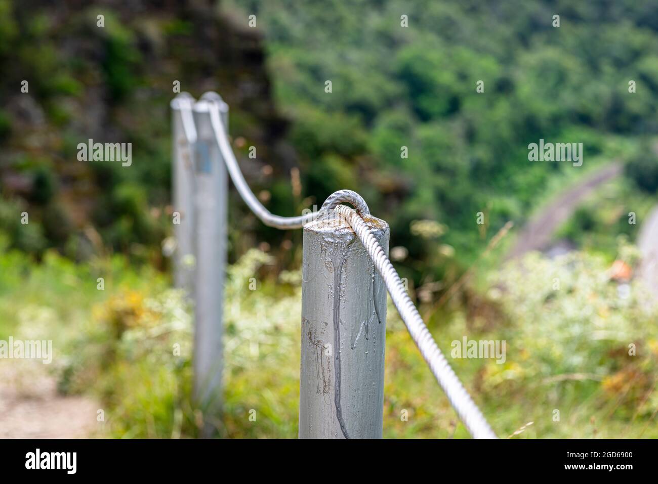 A steel rope passing through the meshes of metal posts over the cliff ...
