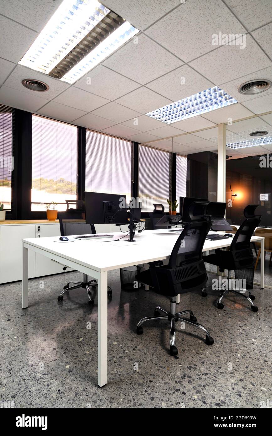modern open space office with computer monitors on white desks Stock Photo