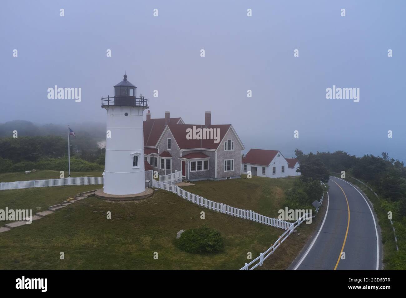 Nobska lighthouse and empty road in fog near Woods Hole, Cape Cod, Massachusetts Stock Photo