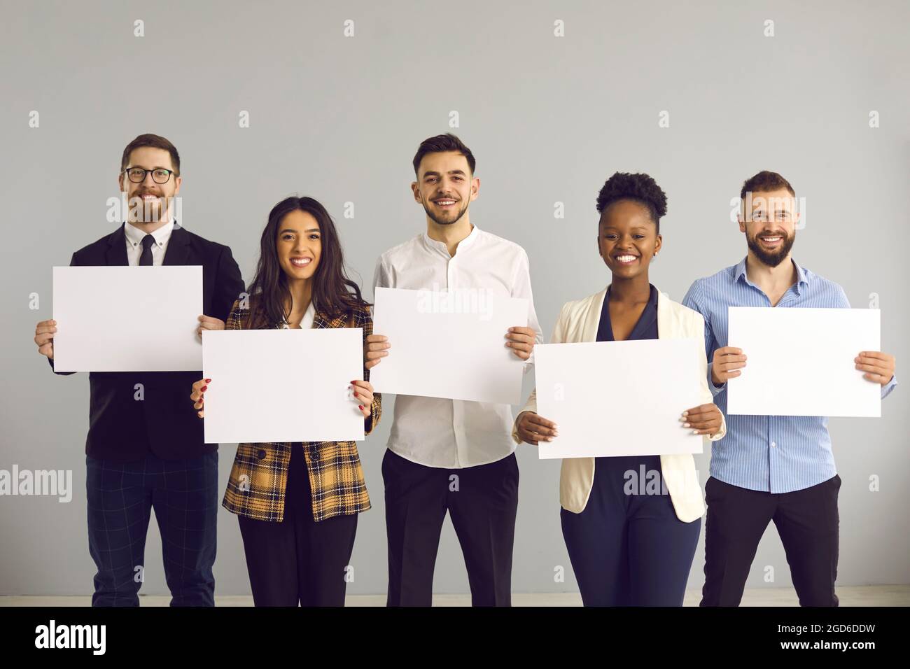 Multi-ethnic diverse business team holding empty paper sheets studio portrait Stock Photo