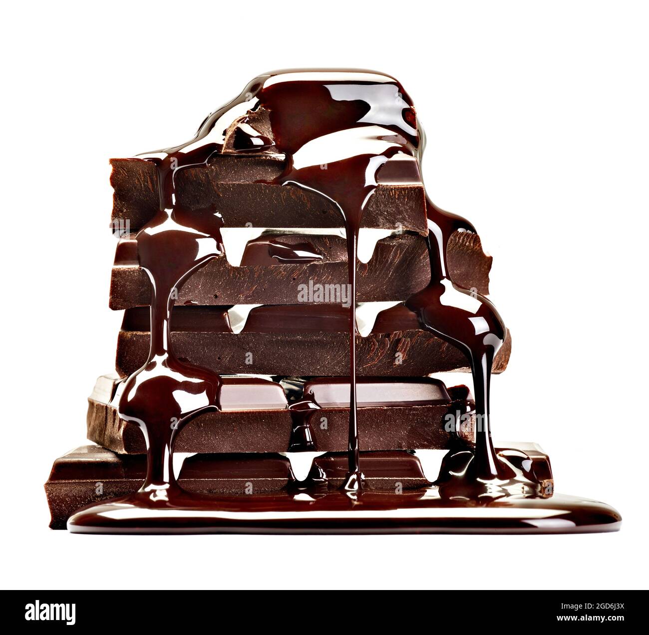 close up of chocolate pieces stack and chocolate syrup on white ...