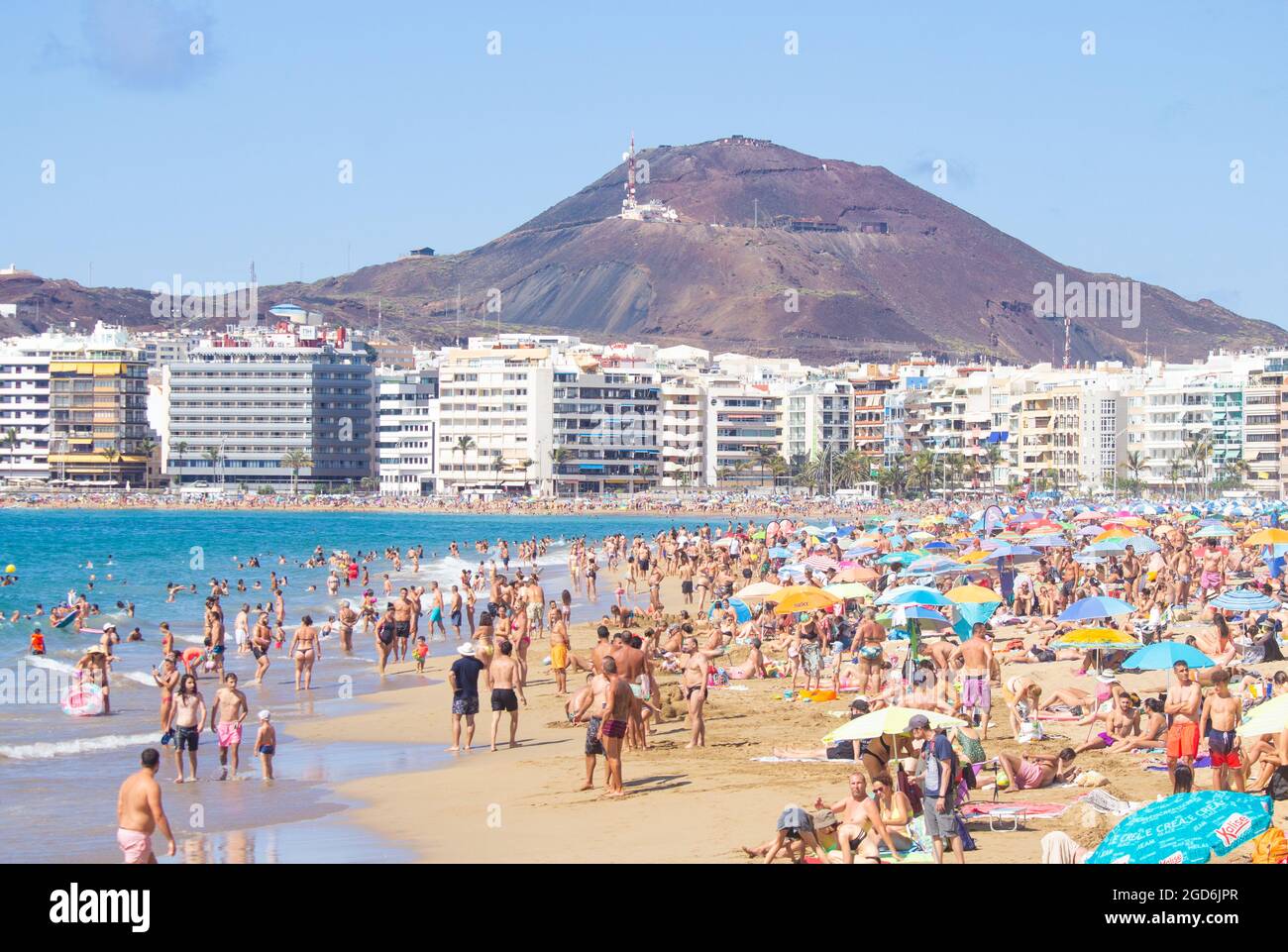 Las Palmas, Gran Canaria, Canary Islands, Spain. 11th August, 2021.  Tourists, many British, basking on a packed city beach in Las Palmas as  temperature hit 36 degrees on Gran Canaria. Temperatures are