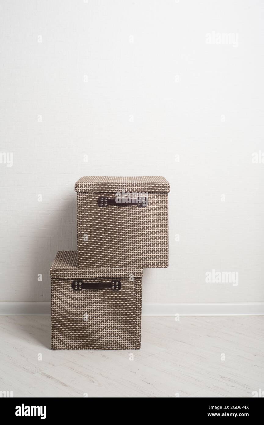 Textile beige and brown storage boxes in white interior. Moving concept Stock Photo