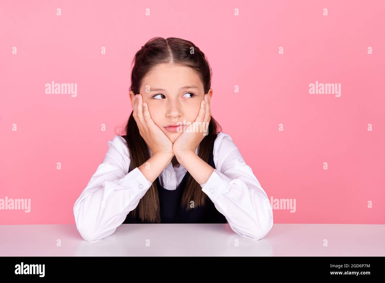 Photo portrait little girl with tails sitting at desk at school bored ...