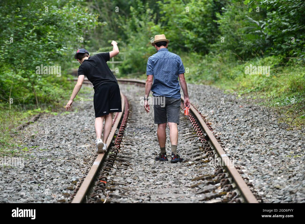 Man and boy walking on disused railway track Britain, Uk gamble gambling Stock Photo