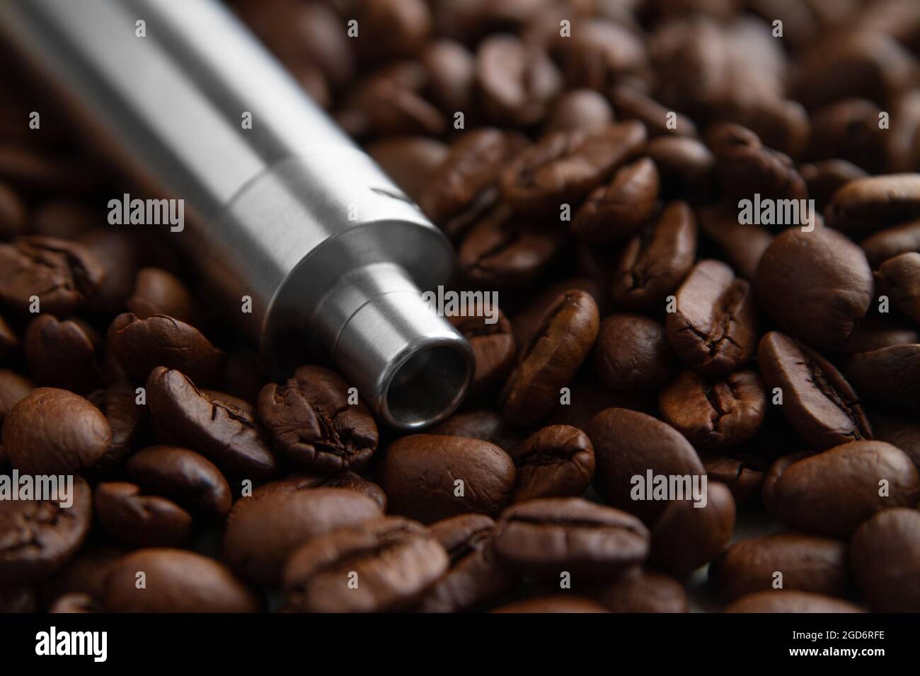 E-cig device mod lies on the background of coffee beans. Concept of vape coffee juice Stock Photo