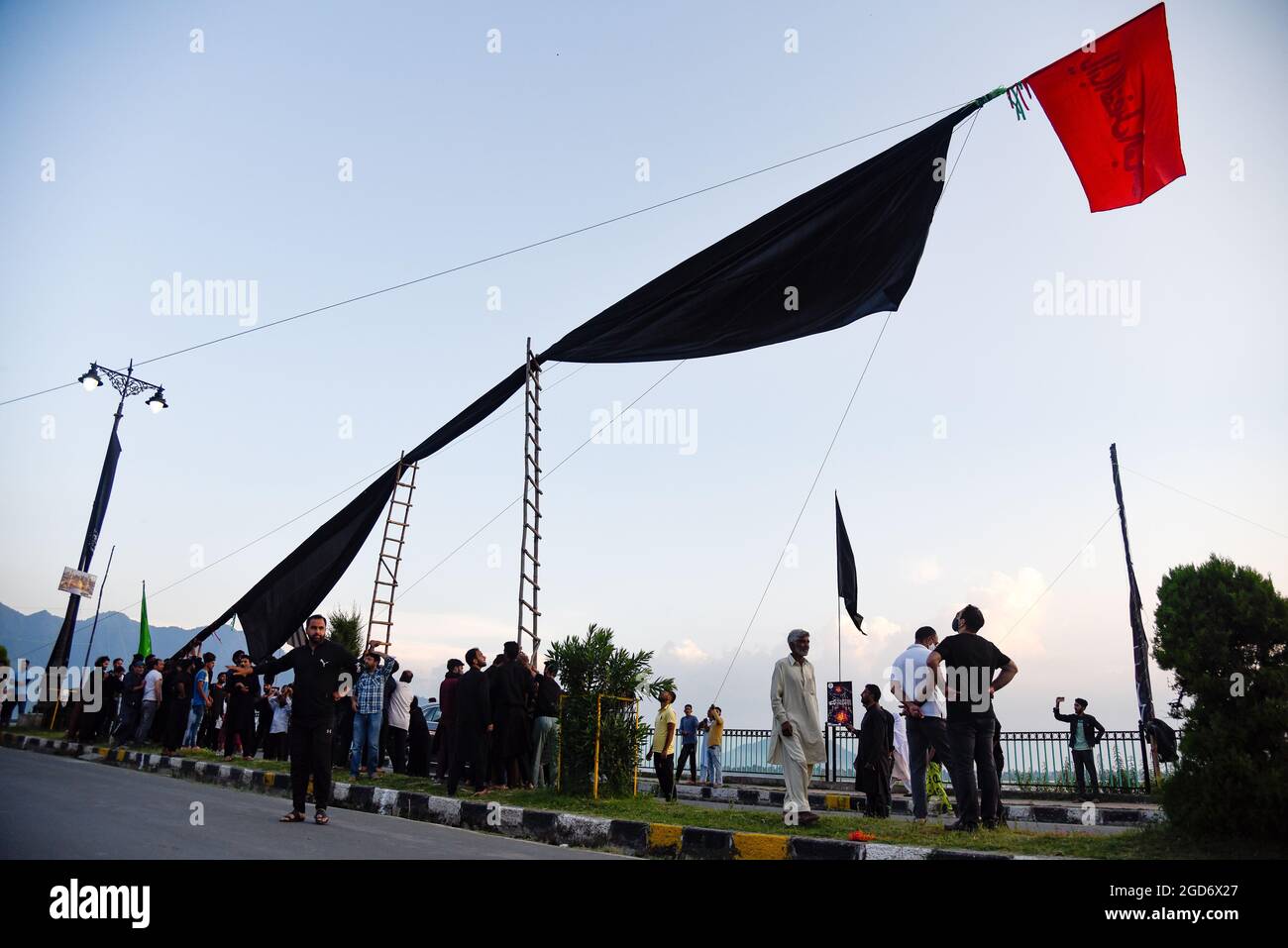 Srinagar, India. 11th Aug, 2021. Kashmiri Shia Muslims erect a 75 feet ...