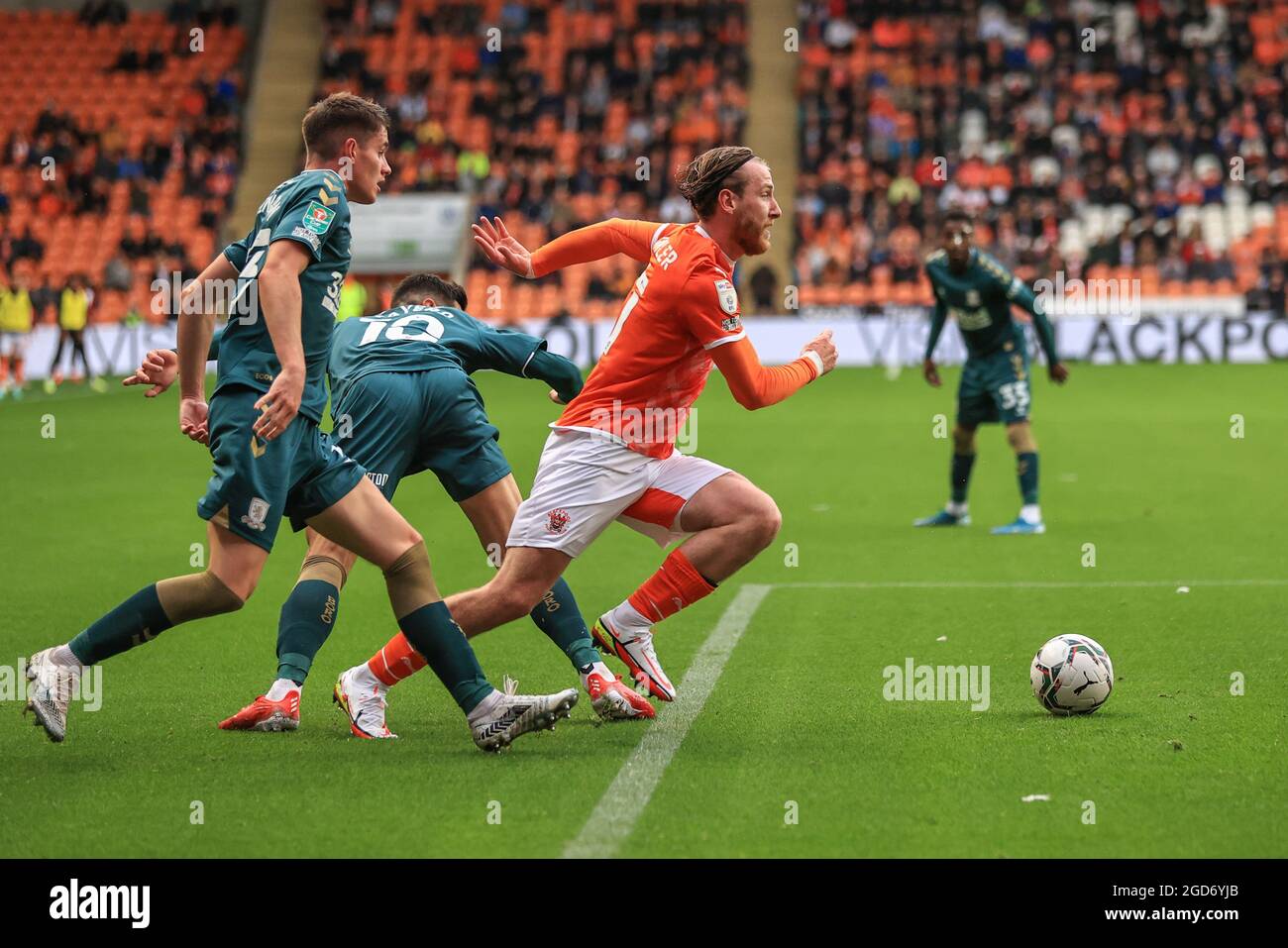 Josh Bowler #11 of Blackpool bursts through Jack Robinson #33 of Middlesbrough and Martin Payero #10 of Middlesbrough to take a shot on goal Stock Photo