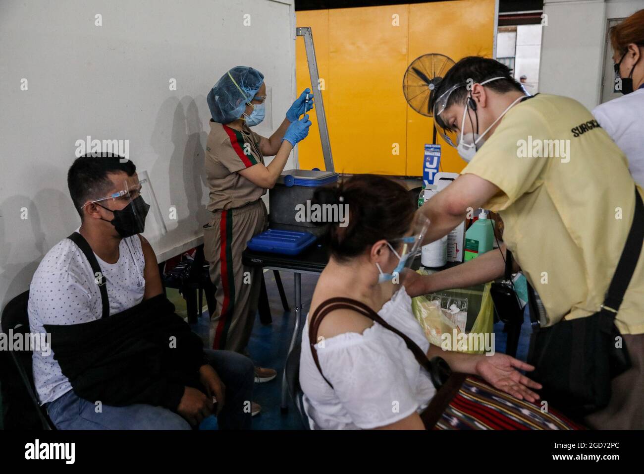 Medical workers inoculate patients with the AstraZeneca COVID-19 vaccine at the University of Santo Tomas. The university opened its vaccination site where about 1,000 doses of the AstraZeneca vaccine were administered by medical clerks and government health workers. Manila, Philippines. Stock Photo