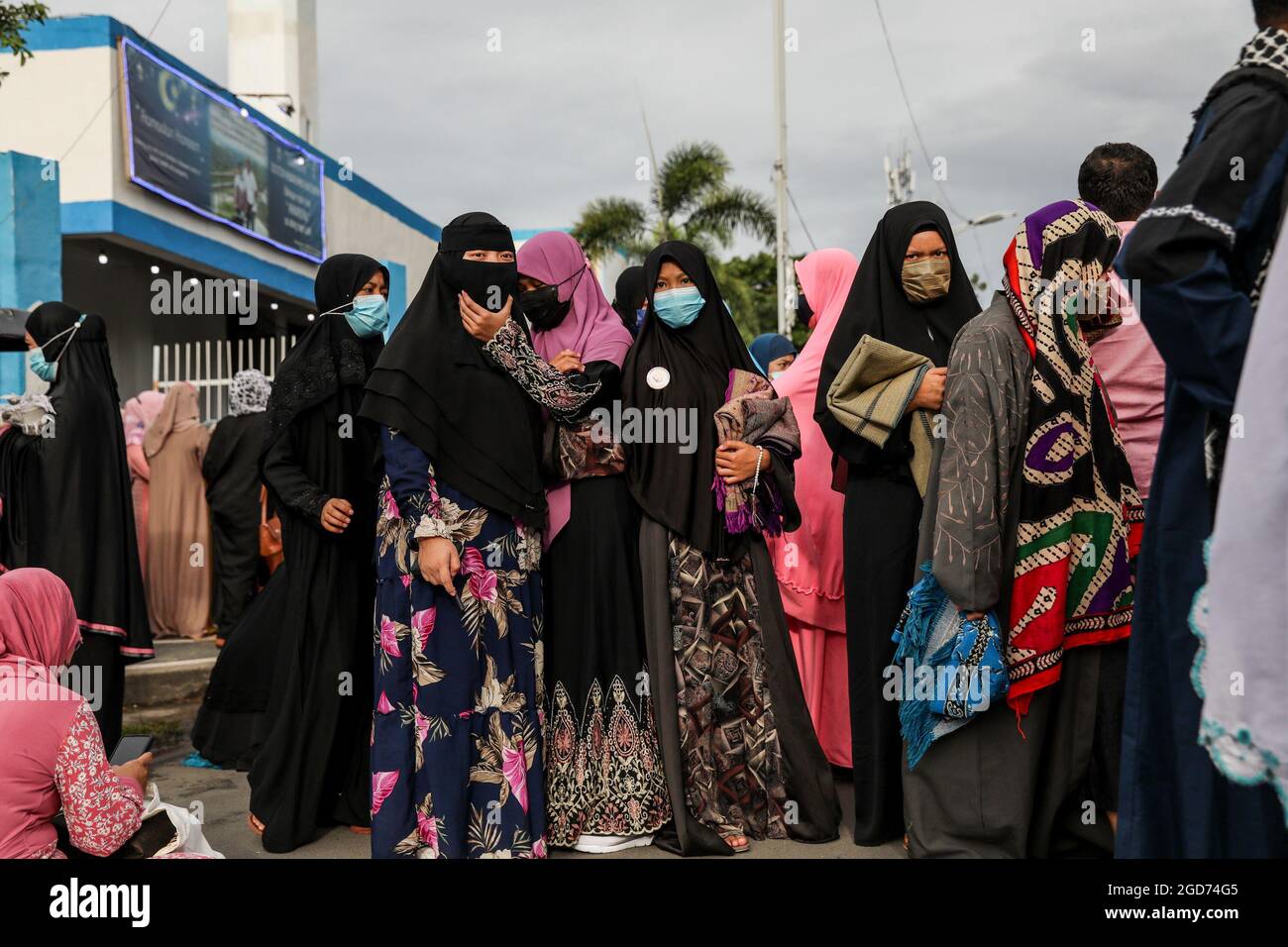 Filipino Muslims wearing protective masks as precaution against the spread of the coronavirus disease attend morning prayers to mark Eid al-Adha at the Blue Mosque in Taguig City, Metro Manila. Despite new waves of coronavirus cases and governments banning large gatherings, Muslims around the world celebrate Eid al-Adha, or the Feast of the Sacrifice, with prayers and the slaughter of goats and cows and their meat being given to the poor. Philippines. Stock Photo