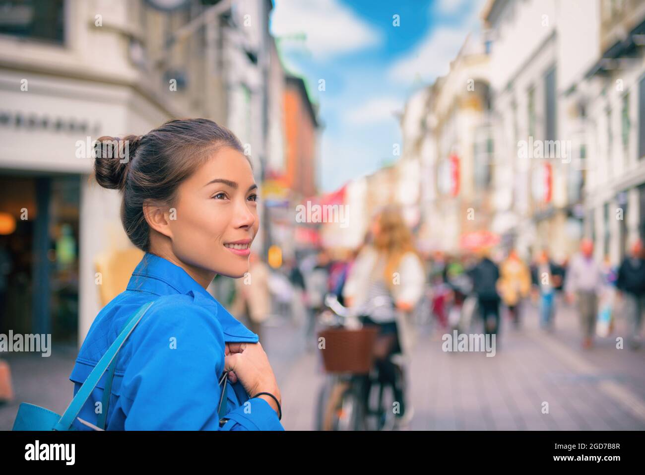 Tourist chinese young woman walking in city street shopping on travel vacation in fall autumn spring happy. Copenhagen city, Denmark Stock Photo