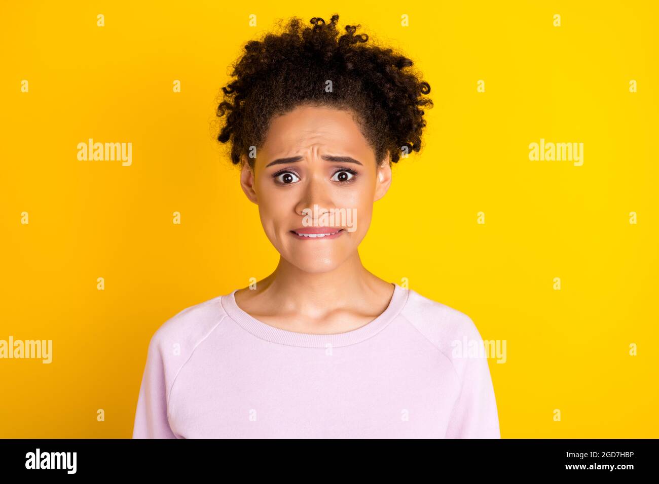 Portrait of horrified dark skin people biting lip look camera panic isolated on bright color background Stock Photo